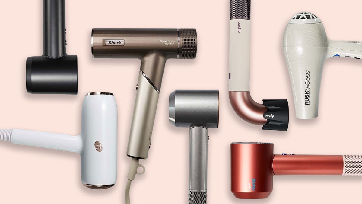 Black hair dryer on marble counter beside towel and round brush