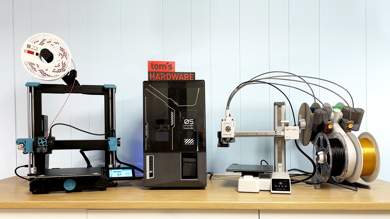 A modern 3D printer creating a geometric object on a clean wooden desk.