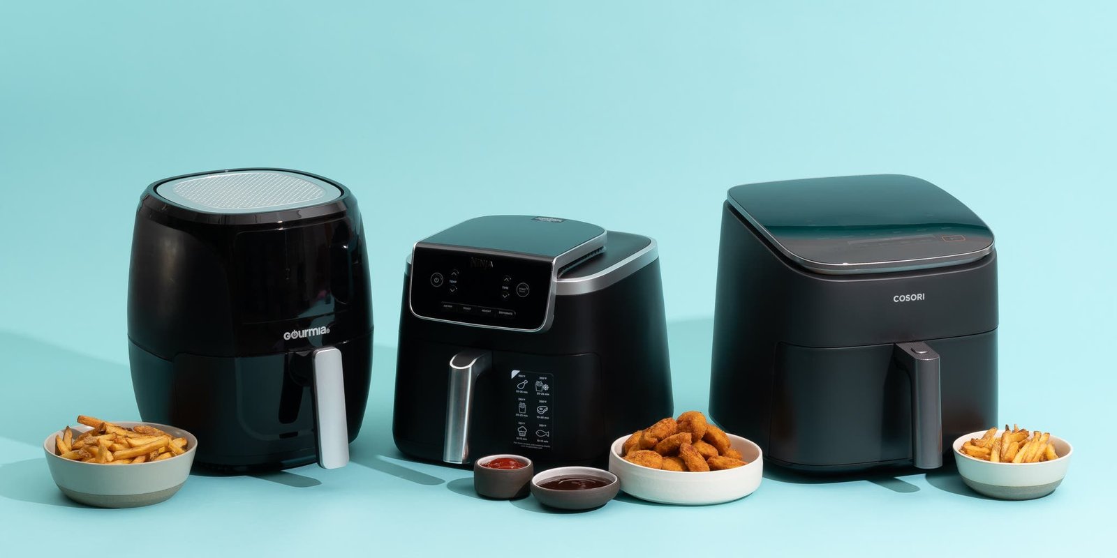 A modern stainless steel air fryer sits on a countertop beside crispy sweet potato fries.